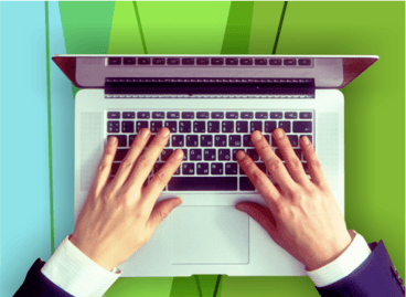 Person's hands typing on a laptop computer on green geometric background.